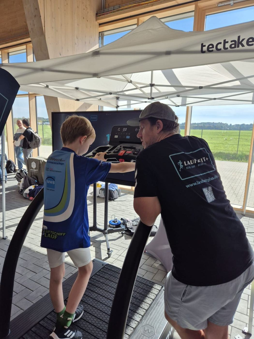 Tobi erklärt einem Jungen am Laufband den Ablauf der Challenge