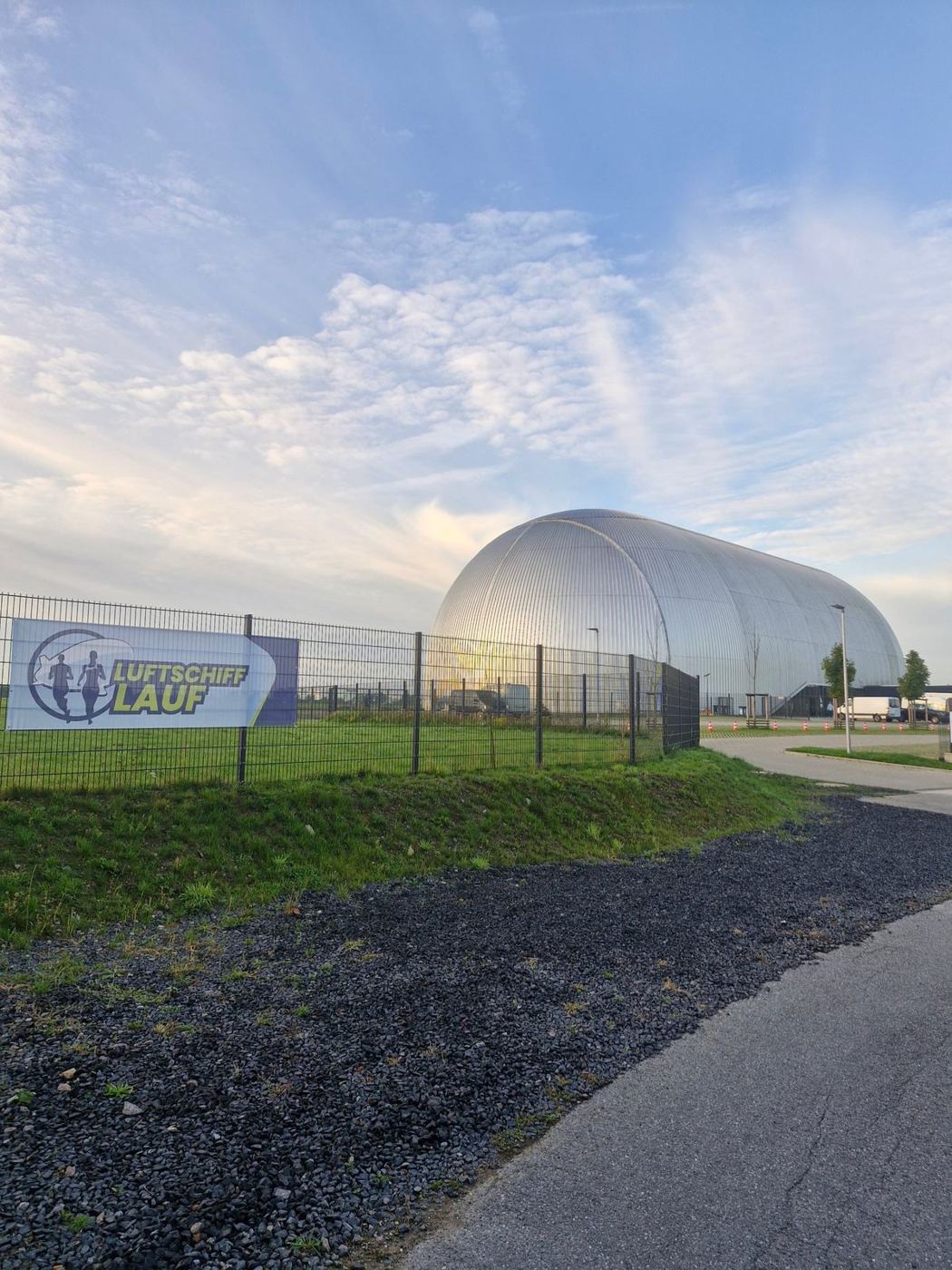 Luftschiffhalle am Morgen mit Luftschifflauf-Banner am Zaun